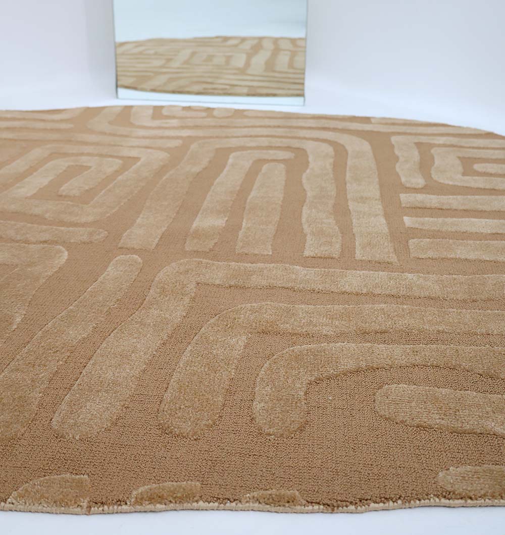 A close-up of the Amazing Brown Color Unshape Decor Rug- CMN 26 (200x300cm) by RAMSHA HOME, featuring a raised geometric maze pattern, placed on a light floor in front of a mirror reflecting the rug and white wall.