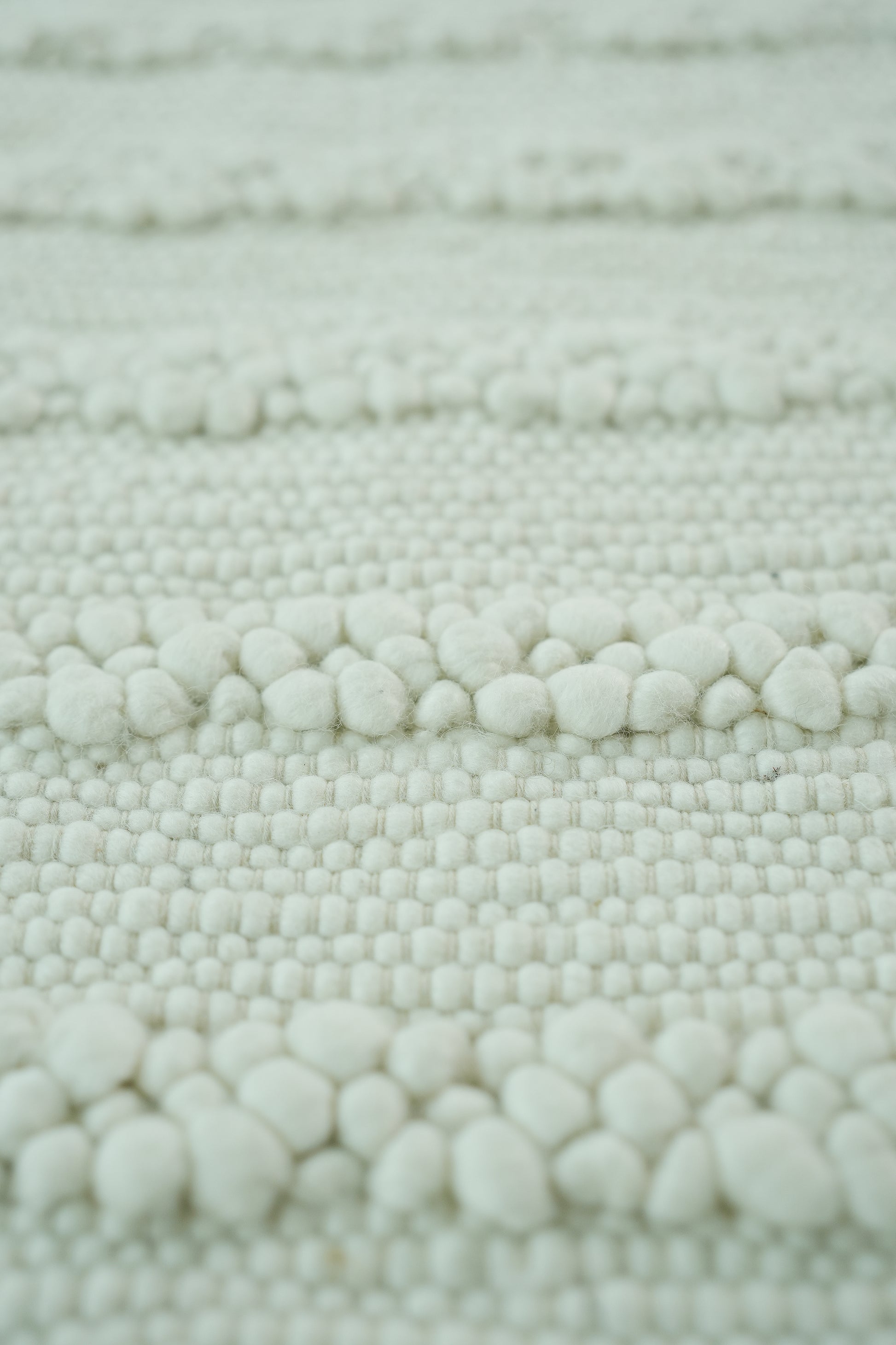 Close-up of the RAMSHA HOME SRN-037 Home Decor Woven Rug in a natural color, featuring raised chunky yarn in horizontal rows for a soft, tactile surface—ideal as a neutral bedroom area rug.