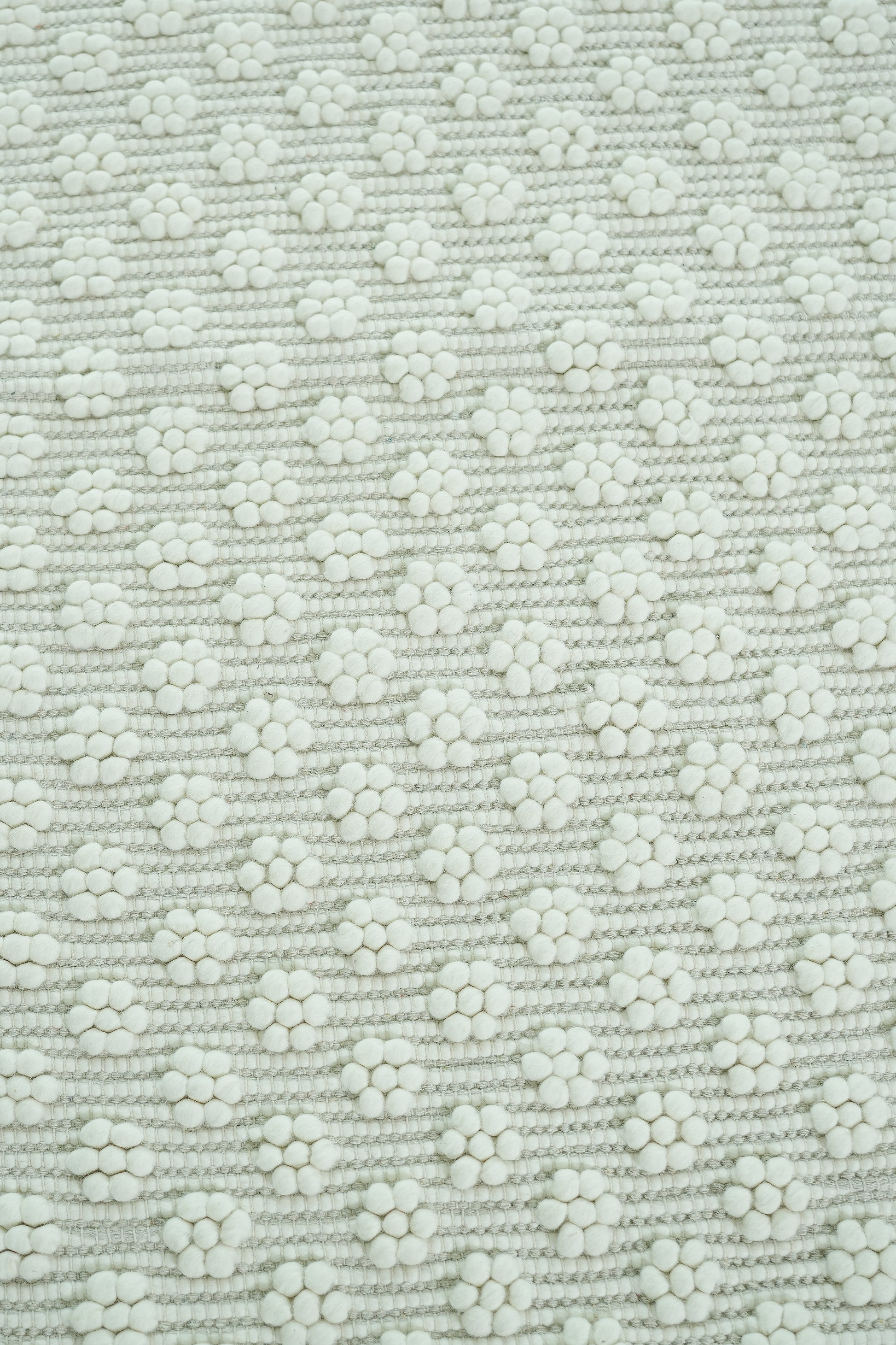Close-up of the RAMSHA HOME Home Decor Woven Rug Natural Color Area Rug SRN-038, featuring a soft, textured weave and repeating white dot floral clusters on a neutral background for an elegant, orderly look.