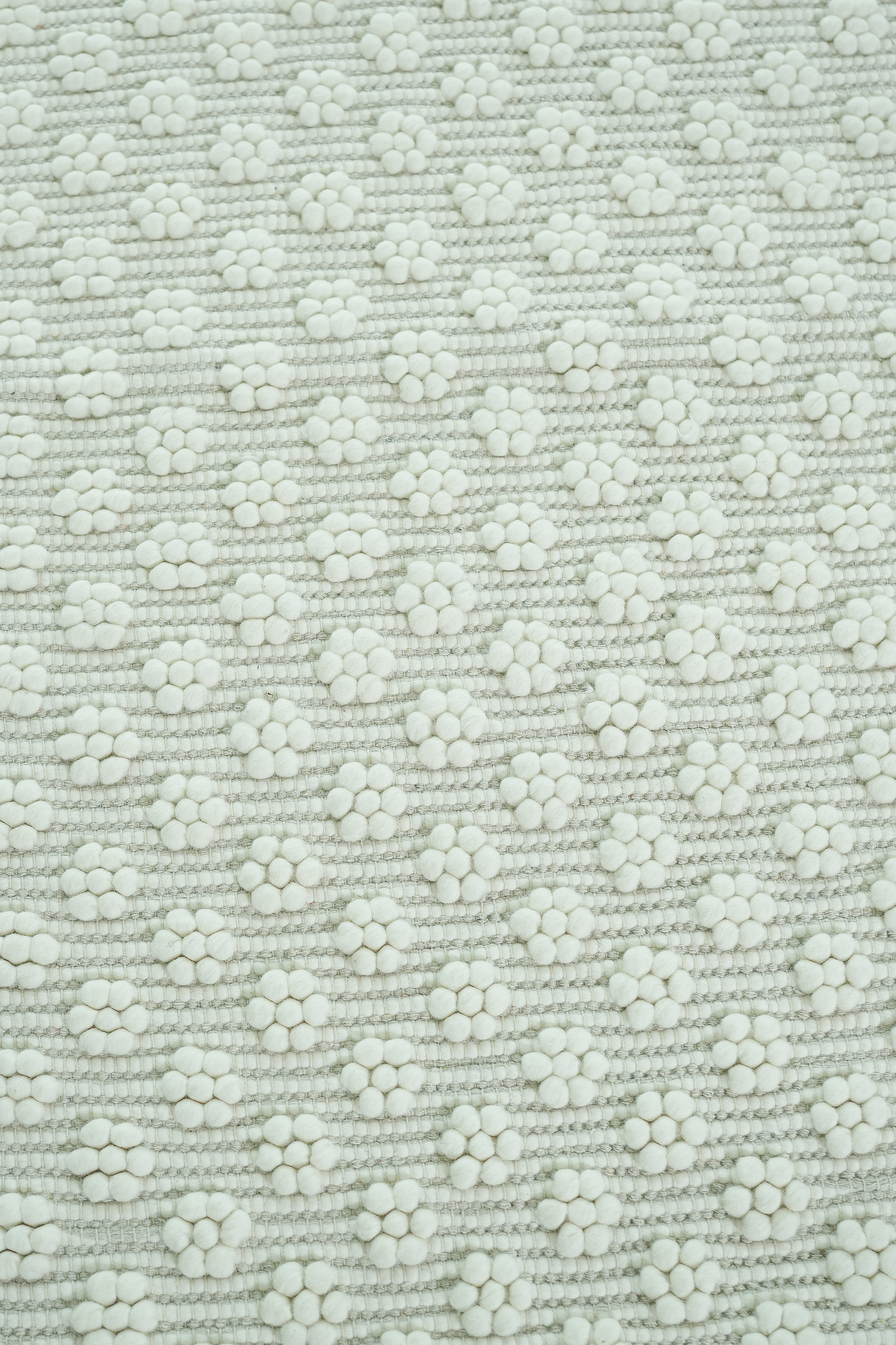 Close-up of the RAMSHA HOME Home Decor Woven Rug Natural Color Area Rug SRN-038, featuring a soft, textured weave and repeating white dot floral clusters on a neutral background for an elegant, orderly look.