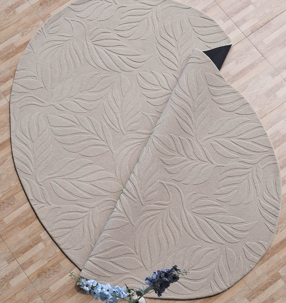 The Premium Off-White Area Carpet - HTW 115 (200x300 cm) by RAMSHA HOME, featuring a raised leaf pattern, is partially folded on a wooden floor with a small bouquet of blue and purple flowers near its edge.