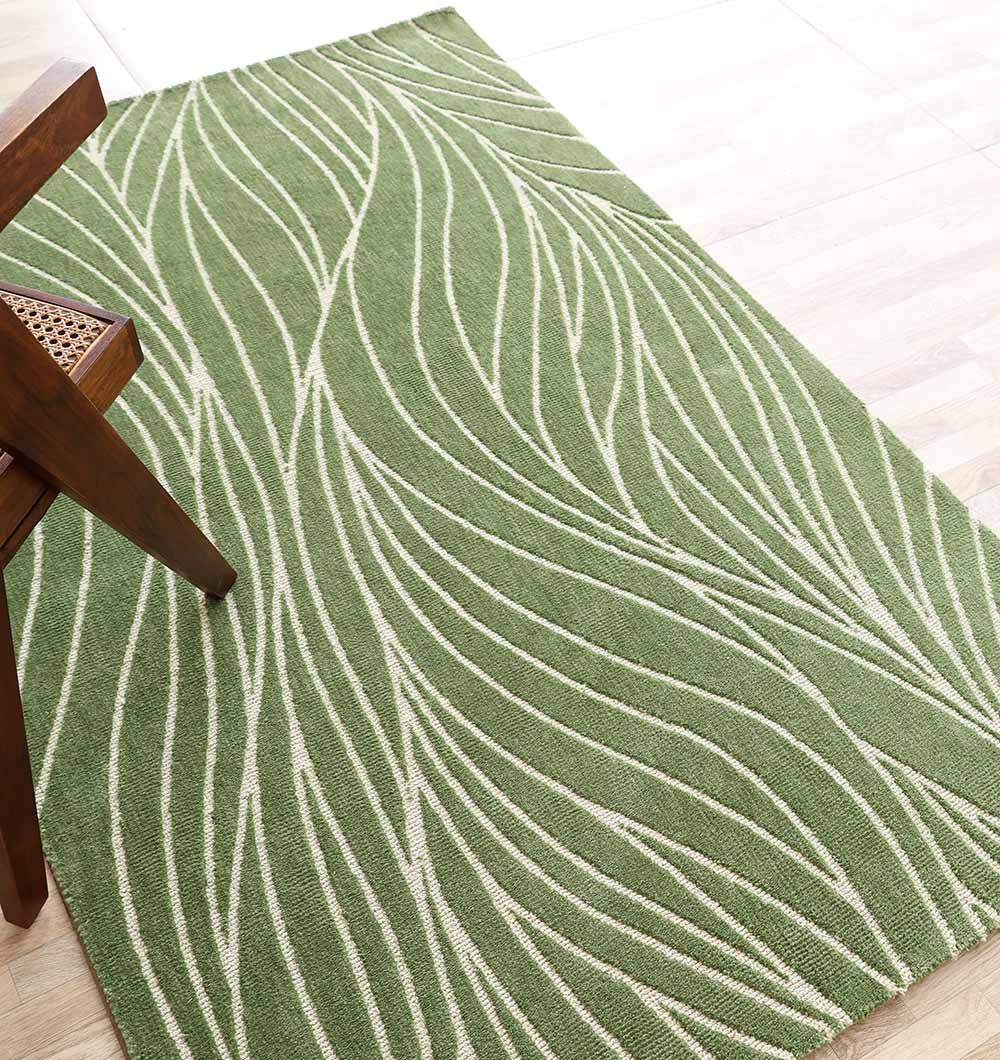 The RAMSHA HOME Leaf Vein Line Pattern Green & Ivory Rug – KD 015, made of polyester, adds natural charm and comfort with its wavy leaf-like design, shown here on a light wood floor beside a wooden chair with a woven cane seat.