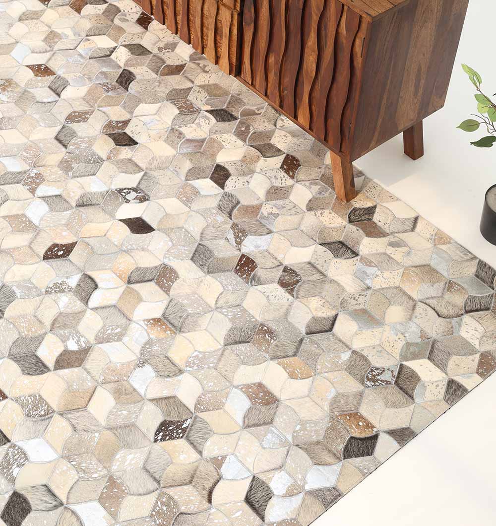 The RAMSHA HOME Amazing Bedroom & Hallway Grey Color Leather Rug - LR 007 features a geometric design, seen in a modern minimalist room with a wooden cabinet and green potted plant partly visible.
