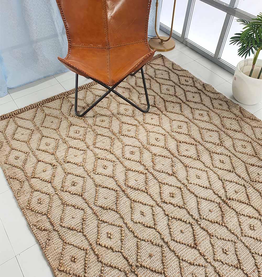 A tan leather chair sits on the RAMSHA HOME Brown Rectangle Area Rug and Carpet for Stylish Living Room SR-004, next to a potted plant by large windows letting in natural light.