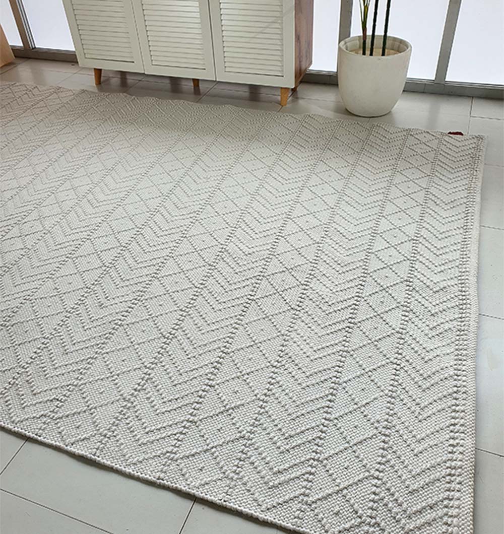 The RAMSHA HOME White Rectangle Woven Area Rug SR-022 adds modern texture to a tiled floor. A white cabinet and a potted plant stand by floor-to-ceiling windows in the background.