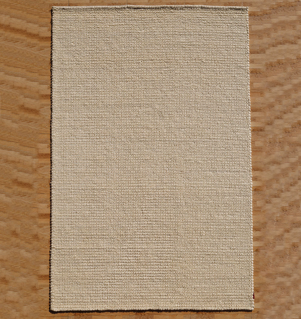 The RAMSHA HOME Handmade Natural Color Woven Rug For Living Room SRN-036 adds warmth and texture to a light wood floor with a subtle zigzag pattern.